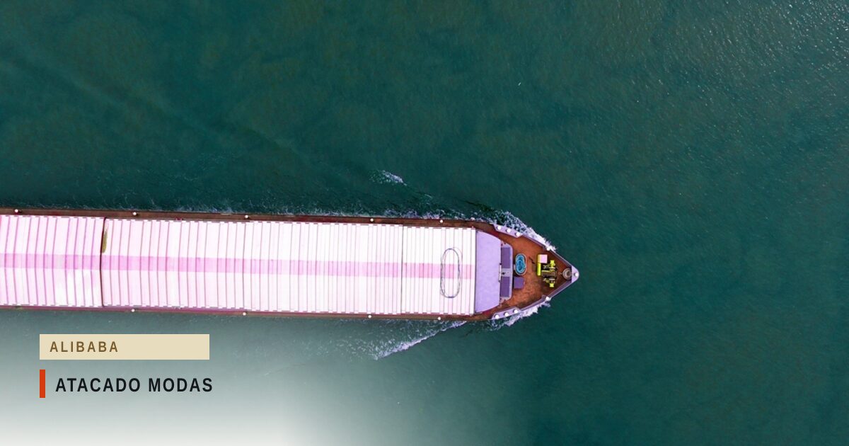 Navio de carga visto de cima, carregado de contêineres, cruzando um mar verde-escuro