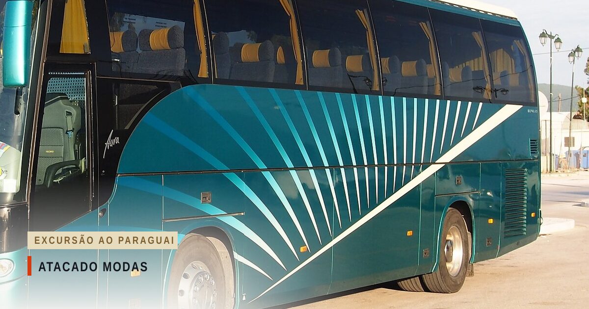Ônibus de turismo verde-azulado, com listras brancas e azuis na lateral, visto de lado, estacionado numa rua