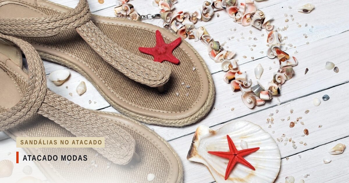 Duas sandálias de dedo trançadas, cor de areia, sobre tábuas brancas, entre conchas, caramujos e estrelas-do-mar vermelhas