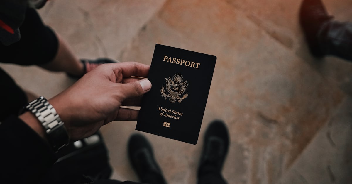 Mãos segurando passaporte e documentos de viagem, na situação típica de quem se prepara para declarar bens na fronteira
